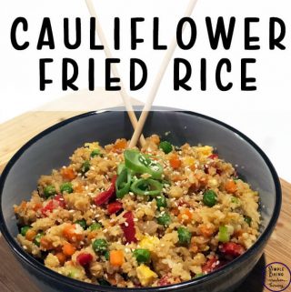 Cauliflower Fried Rice in a black bowl with chopsticks