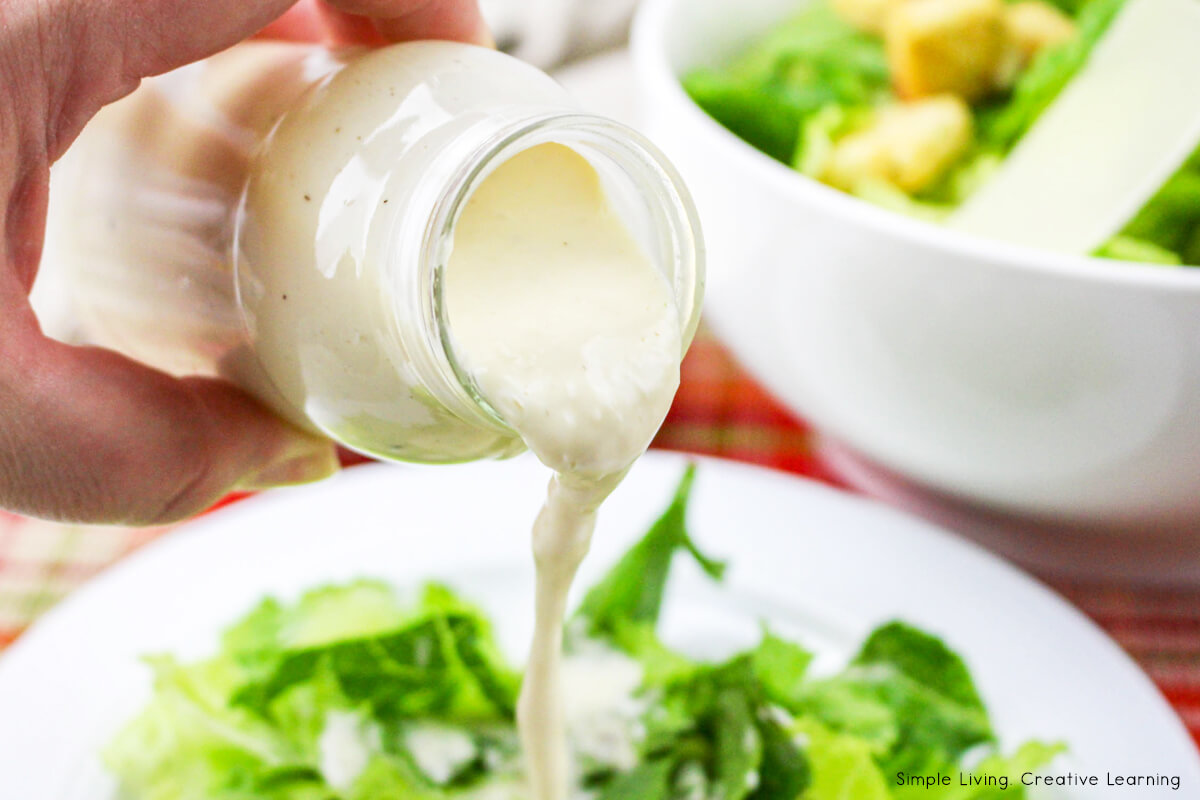 Easy Homemade Caesar Salad Dressing pouring over salad