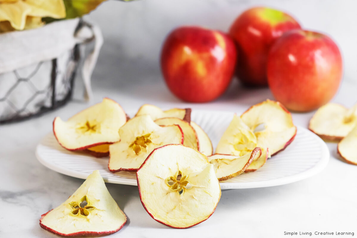 How to Dehydrate Apples on a plate, apples in background