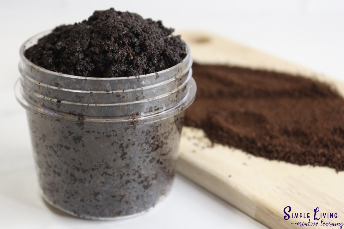 Homemade Coffee Face and Body Scrub in a jar with a wooden board and coffee grinds