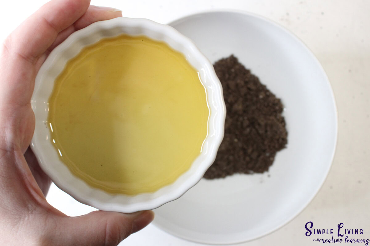 Homemade Coffee Face and Body Scrub pouring infused oil into coffee powder