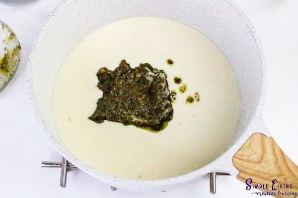 Homemade Alfredo Pesto Sauce adding the basil pesto