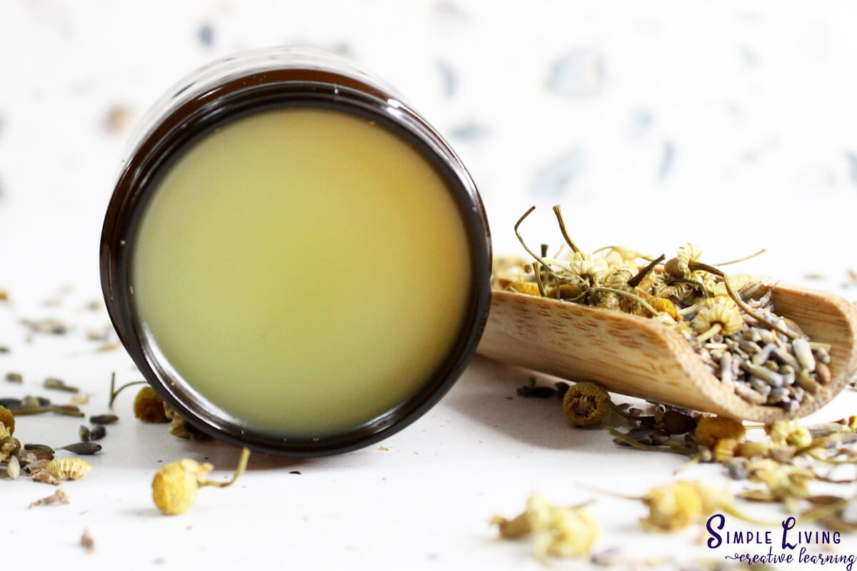 Homemade Natural Sleep Salve in a glass jar that is sitting on its side