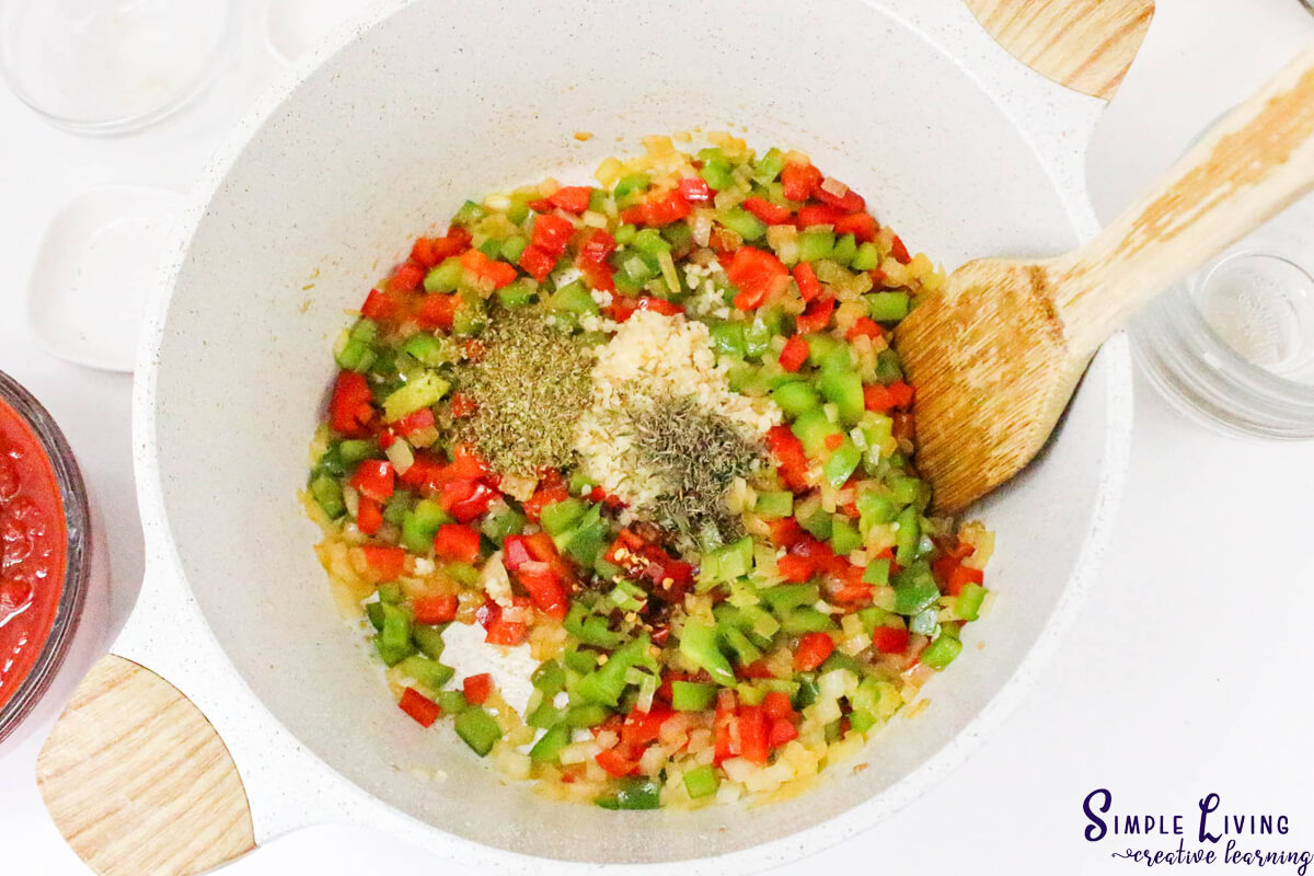 Dutch Oven Chicken Cacciatore adding herbs and spices