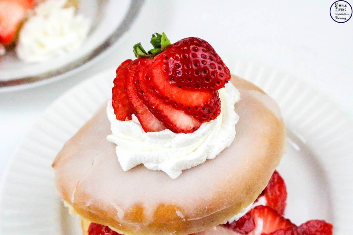 Easy Strawberry Shortcake Donuts add the top of the donut and more cream and strawberries