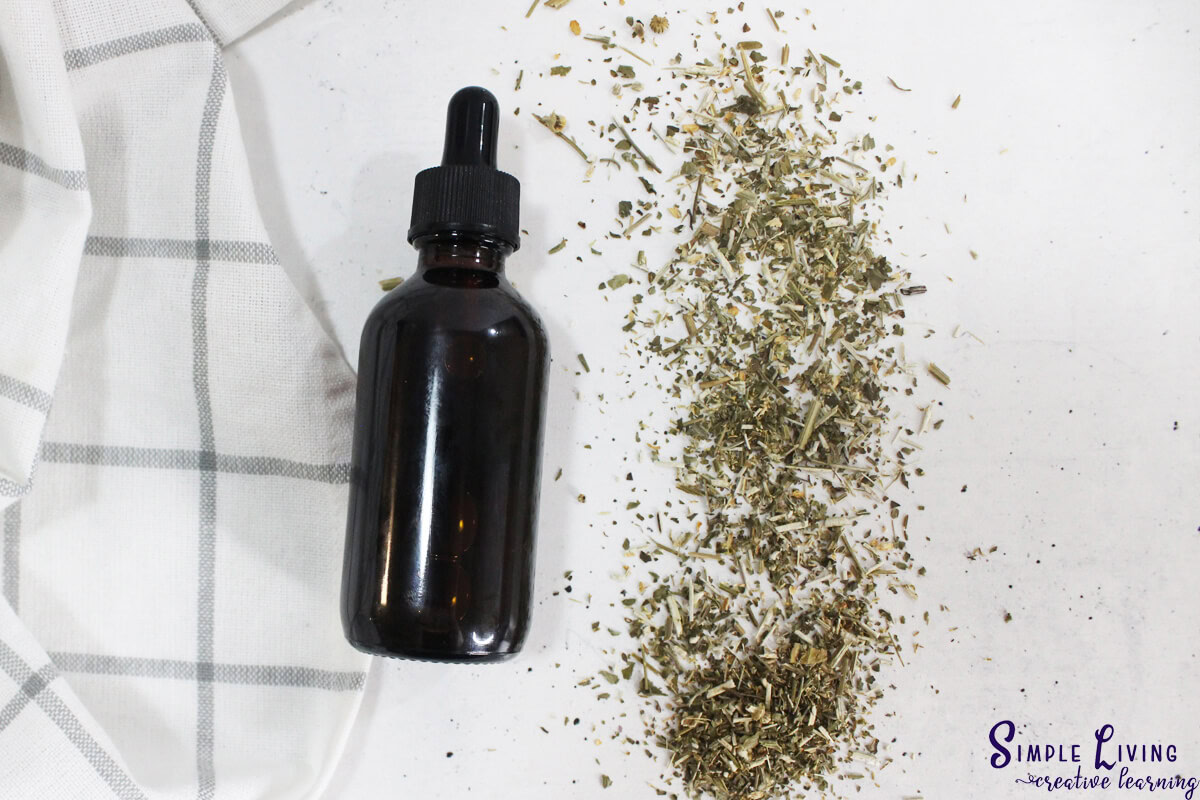 How to Make Feverfew Tincture laying on a cloth with dried flowers next to it