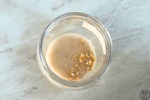How to Rehydrate Dried Sourdough Starter adding water to the dried starter in jar