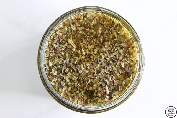 Homemade Oregano Infused Oil adding the carrier oil