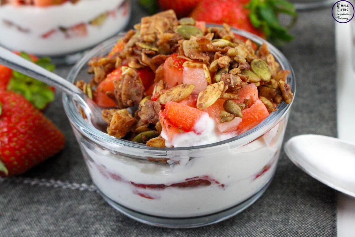 Strawberry Yoghurt Parfaits with a spoon enjoying