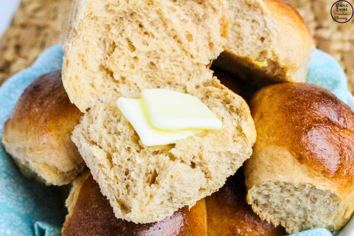 Whole Wheat Dinner Rolls one cut open with butter on it
