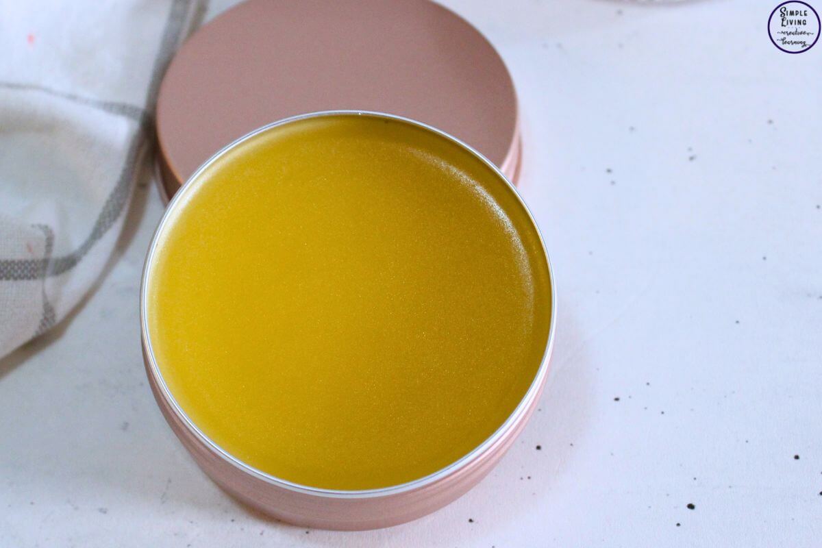 Homemade Frankincense Salve in a tin sitting on the tin's lid