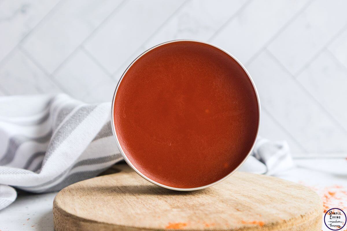 homemade cayenne salve in a tin sitting on its side