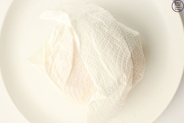 Freezer Friendly Sausage and Egg Muffins wrapping in paper towel to reheat