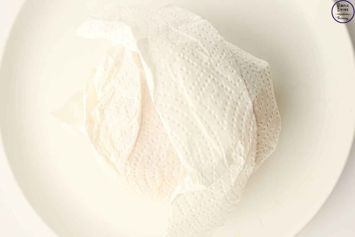 Freezer Friendly Sausage and Egg Muffins wrapping in paper towel to reheat