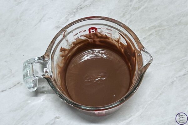 Mars Bar Slice melted chocolate ready to pour on top