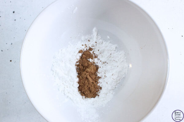 Homemade Dry Shampoo Recipes adding arrowroot powder and cocoa powder to a bowl