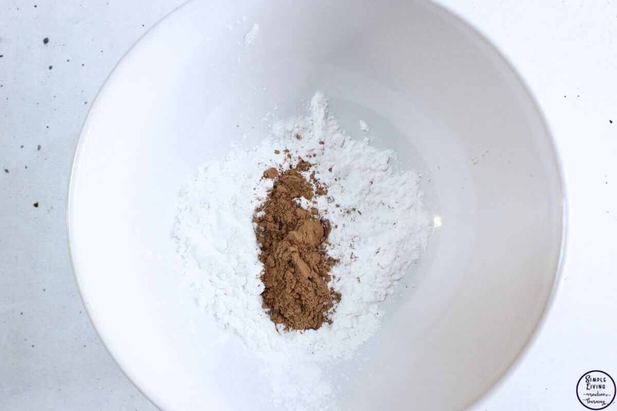 Homemade Dry Shampoo Recipes adding arrowroot powder and cocoa powder to a bowl
