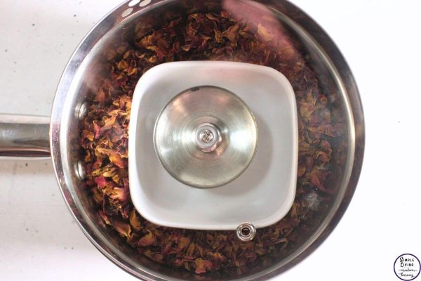 Homemade Rose Hydrosol adding the lid to the saucepan